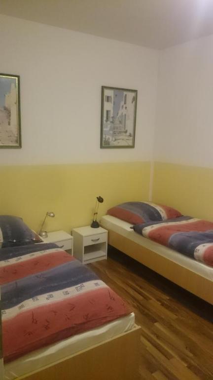 2 Betten in einem Zimmer mit Holzböden in der Unterkunft Apartment Dorn in Jüchen