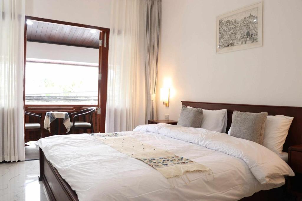 ルアンパバーンにあるMyluangprabangguesthouesの大きなベッドと窓のある寝室