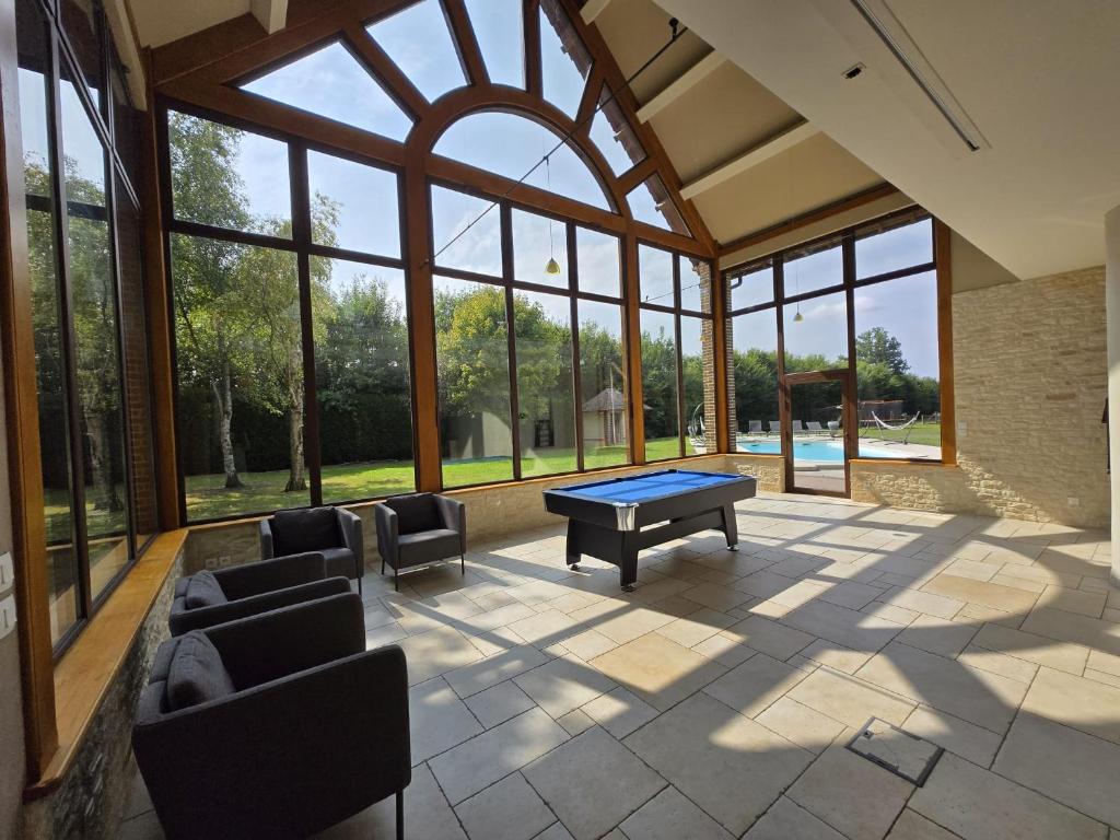 にあるVilla de luxe, piscine chauffée & natureの卓球台と椅子が備わる広い客室です。