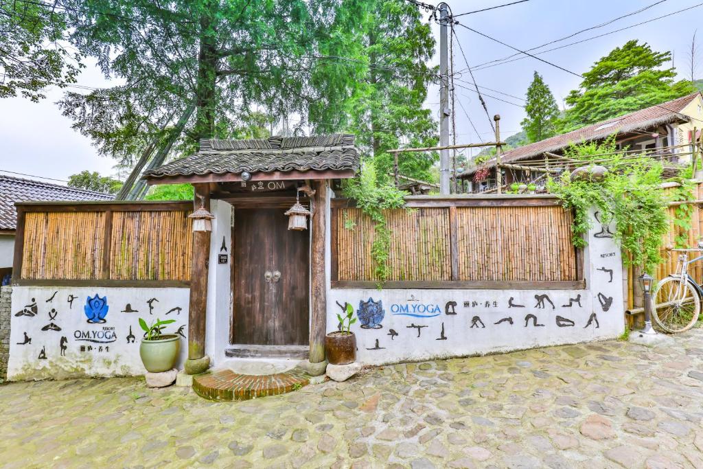 a small house with a door and a fence at Om Yoga Resort in Deqing