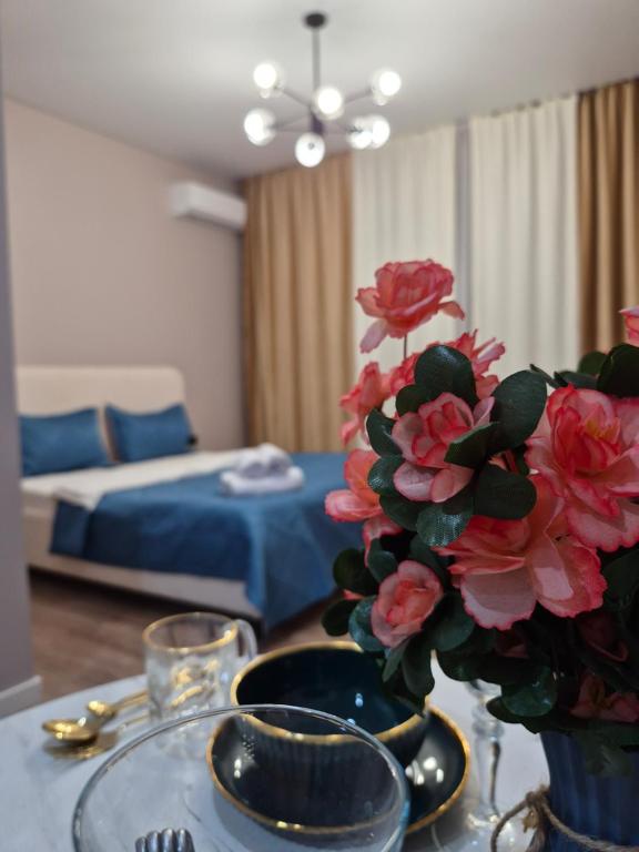 a living room with a table with a vase with flowers at Love Nest in Almaty