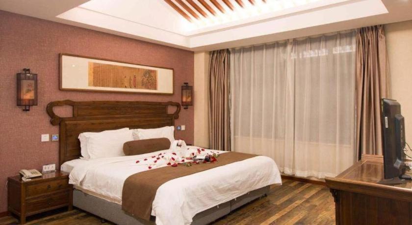 a bedroom with a bed with red roses on it at James Joyce Coffetel Xian Dayanta Metro Station Branch in Xi'an