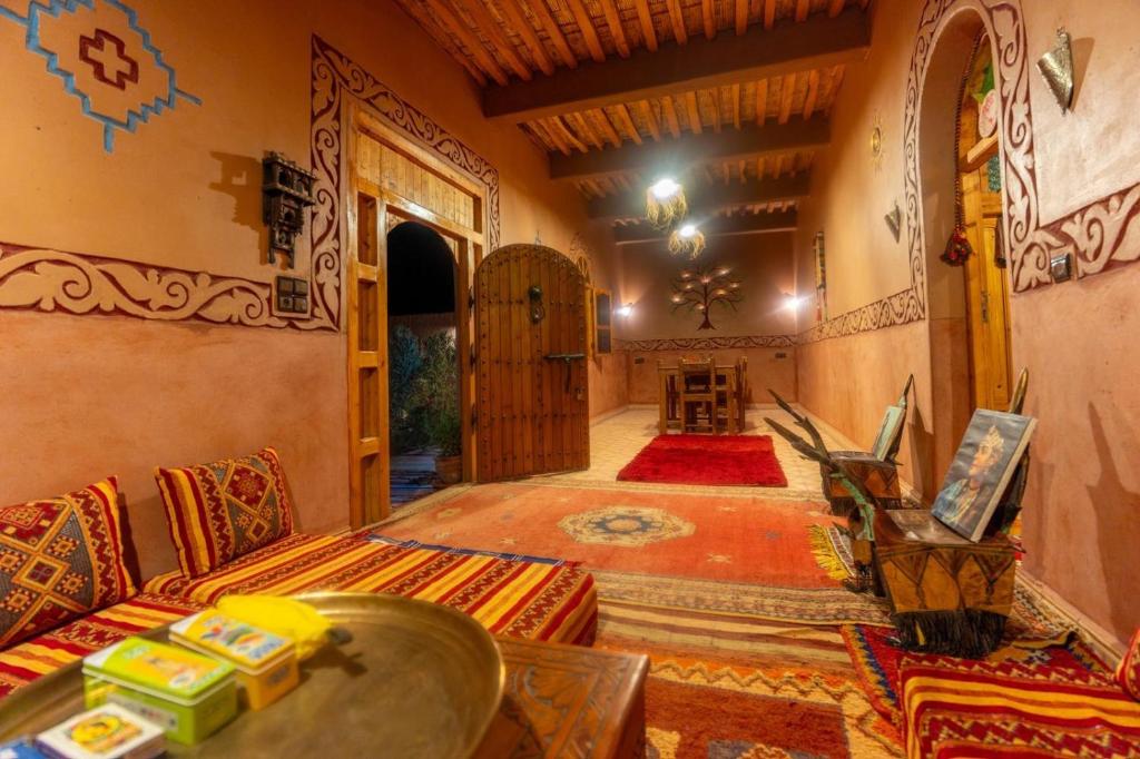 a living room with a couch and a table at Riad Imuhar Prestige - Mhamid Desert Retreat in Mhamid