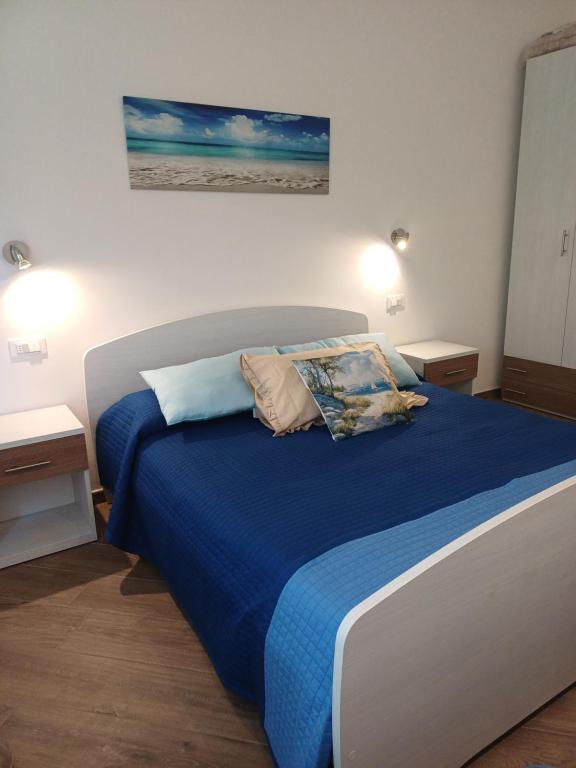 a bedroom with a bed with blue sheets and pillows at Appartamento Chiara in Roseto degli Abruzzi