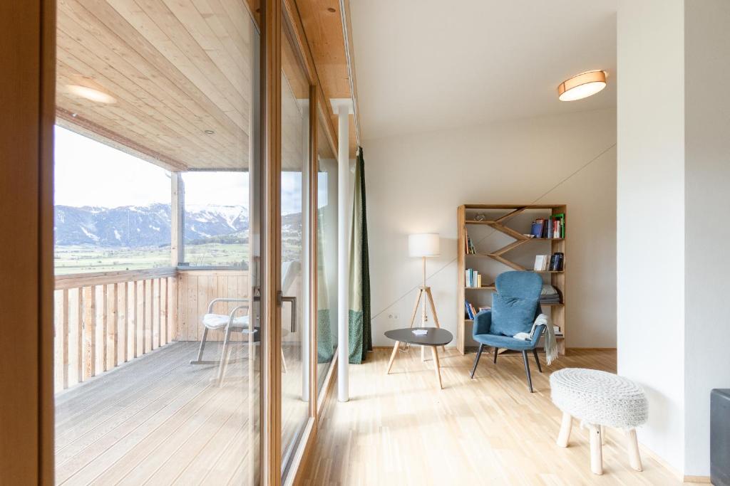 a room with a balcony with a table and chairs at Haus Weigt - Appartement das Grüne in Mariapfarr