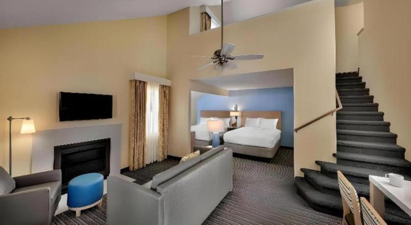 a hotel room with a bed and a living room at Chicago - Lombard in Highland Hills