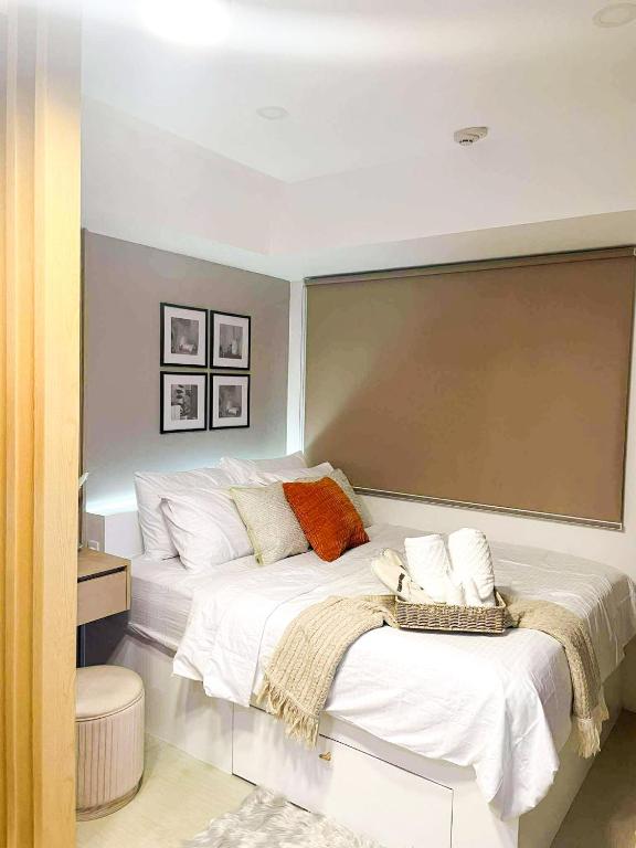 卡加盐德奥罗Emetheria Residence CDO的卧室里有一张床，床单是白色的，枕头是橙色的