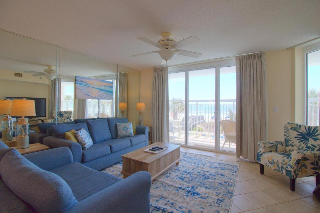 a living room with a blue couch and chairs at Crescent Shores South - 108 in Myrtle Beach