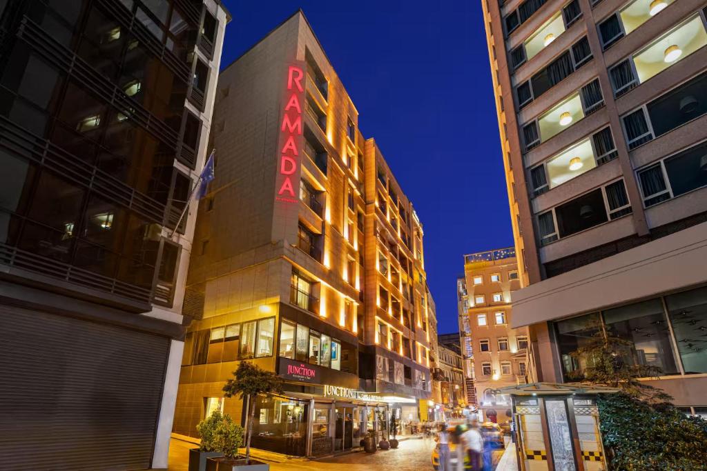 a building with a red sign on the side of it at Ramada By Wyndham Istanbul Pera Taksim in Istanbul