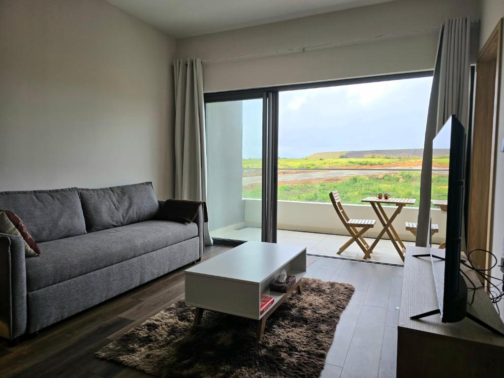 a living room with a couch and a table at Elandor Suite East Minissy Moka in Moka