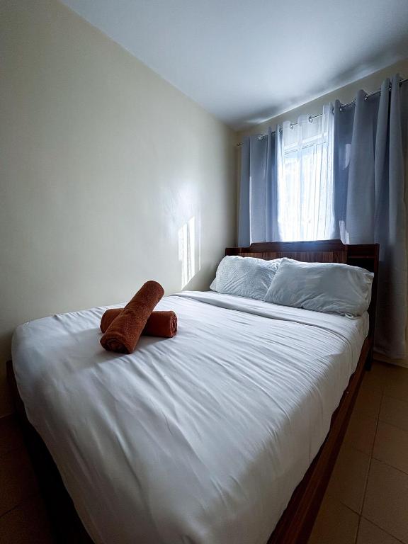 a bed with a stuffed animal sitting on top of it at Modern 2BR Escape Overlooking the Iloilo River in Mandurriao