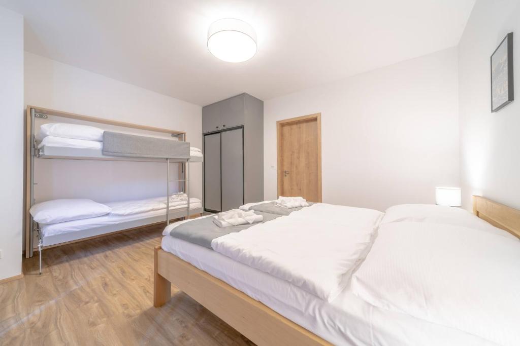 a bedroom with a large bed and bunk beds at Apartmán Vlčice 419 in Trutnov