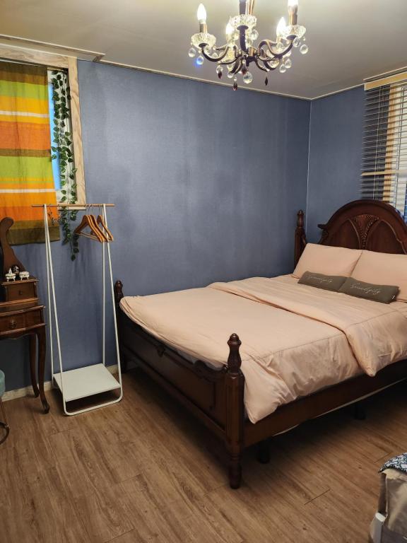 Un dormitorio con una cama y una lámpara de araña en sunset, en Jeonju