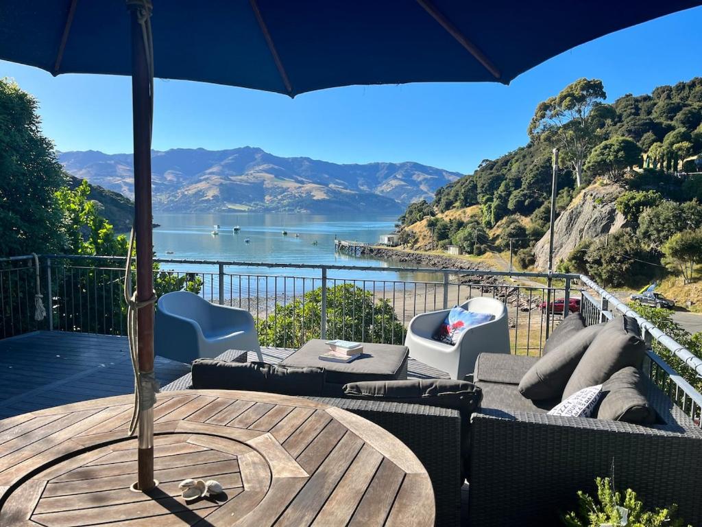 a patio with an umbrella and a table and chairs at Beachfront Tranquility in Tikao Bay in Wainui