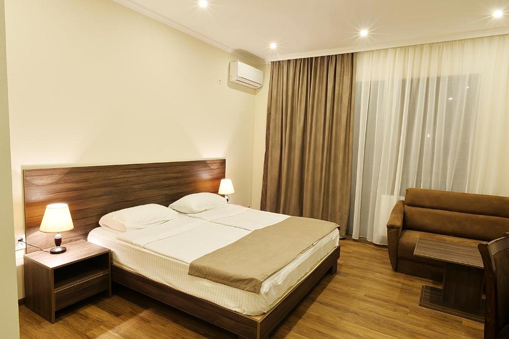 En eller flere senge i et værelse på MGK Hotel