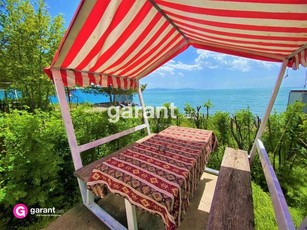 a bed under a canopy with a view of the ocean at Nirvana in Sevan