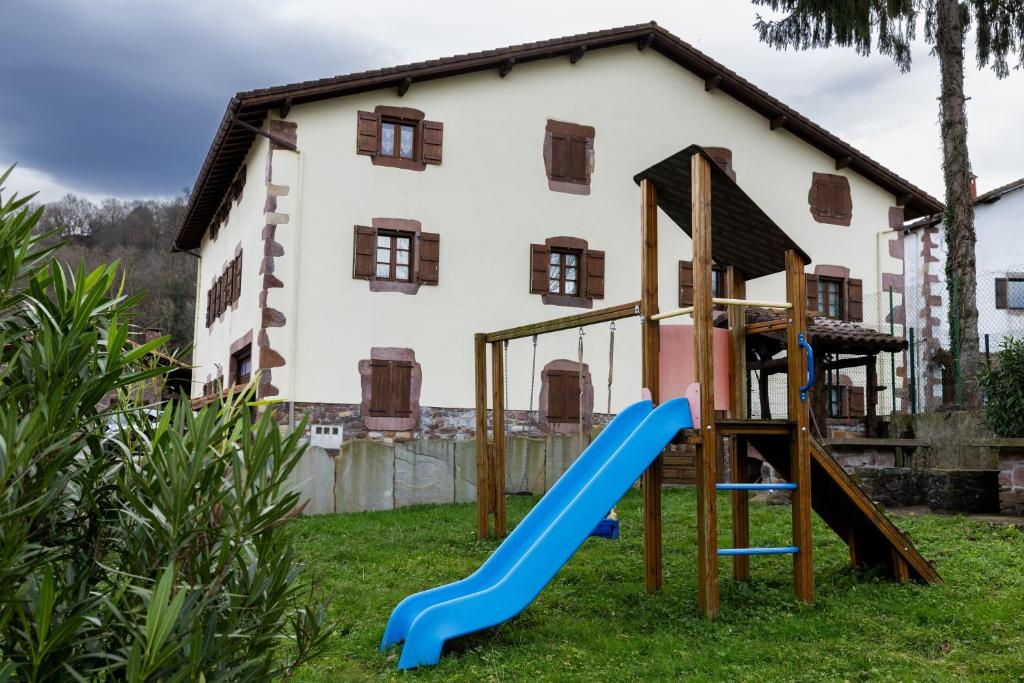a playground with a slide in front of a house at Matxingonea 1 in Urdax