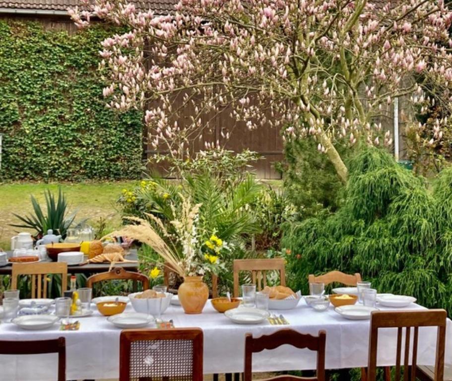 una mesa con un mantel blanco y sillas en un jardín en Gästehaus Schlamau19, en Schlamau