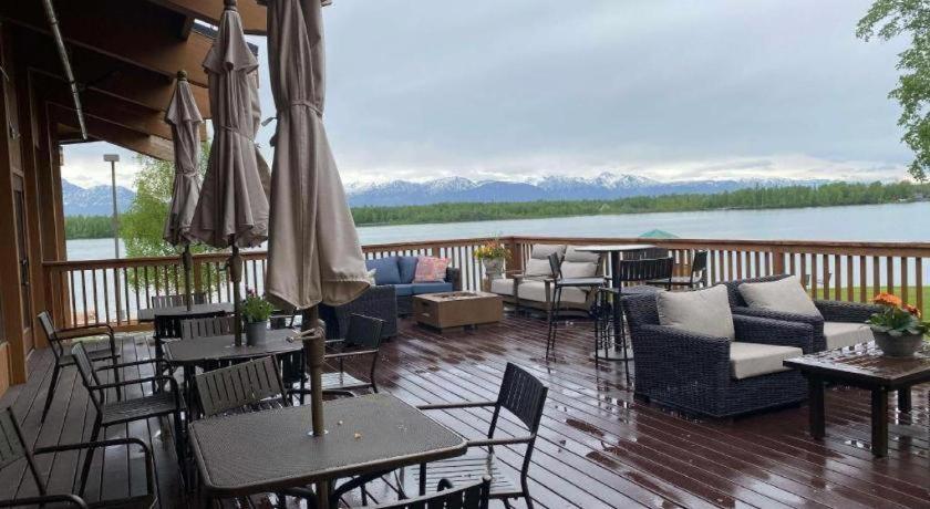 a deck with tables and chairs and a view of a lake at Best Western Lake Lucille Inn in Wasilla