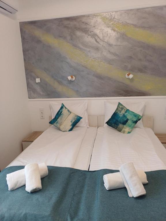 a large white bed with two pillows and a painting at Villa Fogarasi in Târgu-Mureş