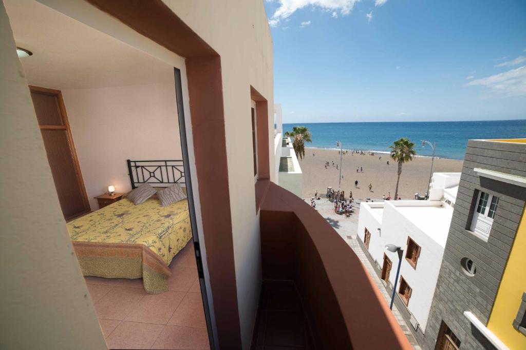 グラン・タラハルにあるApartamento con ascensor Gran Tarajal Playaのビーチの景色を望むベッドルーム1室(ベッド1台付)が備わります。