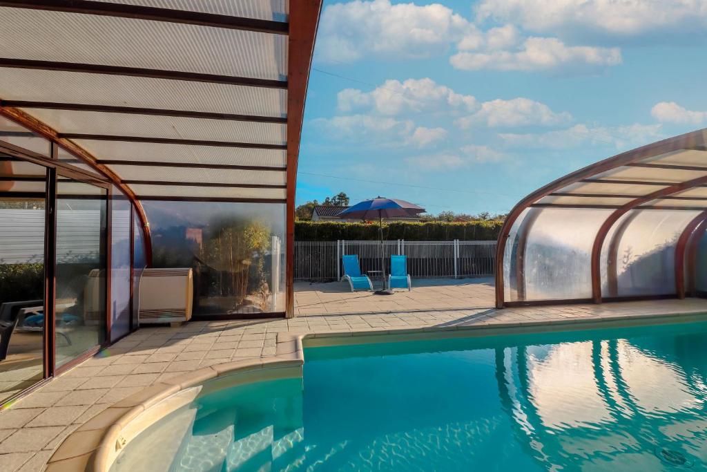 ein Schwimmbad mit Pavillon neben einem Haus in der Unterkunft Maison Tournesol in Escloux