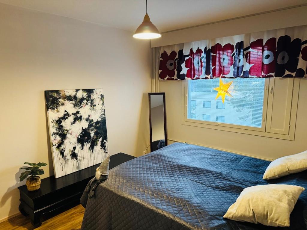 a bedroom with a blue bed and a window at Cozy apartment in Rovaniemi! in Rovaniemi