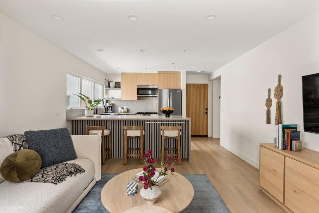 a living room and kitchen with a couch and a table at Tide House - Unit B - Modern Seaside 1BD w Parking in El Segundo