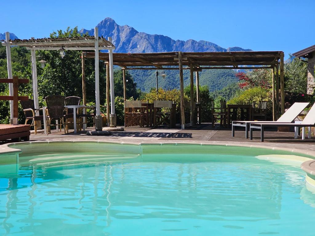 a swimming pool with a picnic table and mountains in the background at Spino Fiorito Stay in Casola in Lunigiana