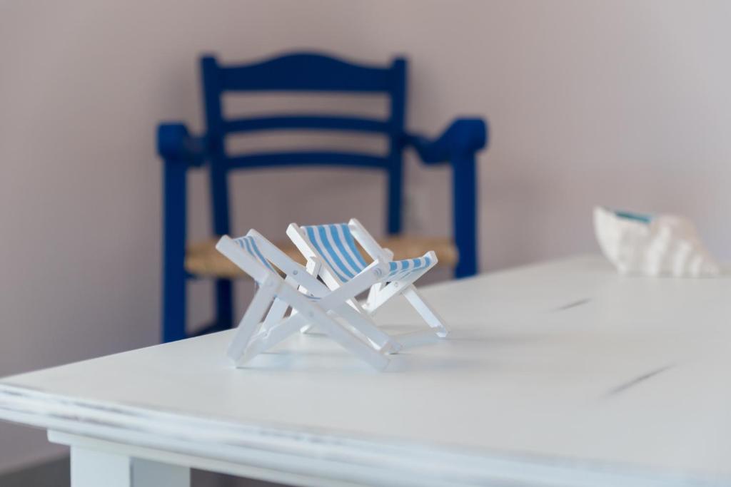 un paio di sedie sedute su un tavolo bianco con una sedia blu di Elounda Sea Suites a Eloúnda