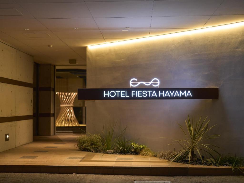 Un letrero de fiesta hawaiana del hotel en el lateral de un edificio en ホテル フェスタ 葉山, en Hayama