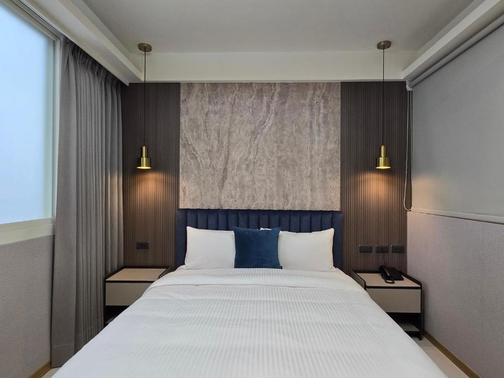 a bedroom with a large bed with two night stands at Fun Stay Inn Hanzhong in Taipei