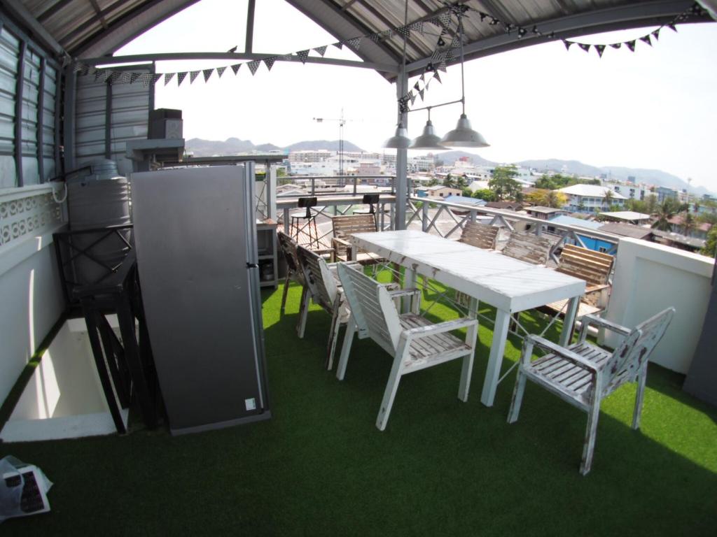 Jetty Huahin Hostel في هوا هين: طاولة بيضاء وكراسي على شرفة