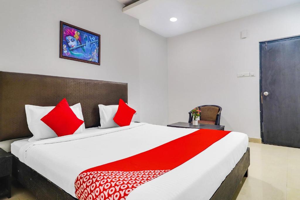 a bedroom with a large bed with red pillows at Super Hotel O Qualia Hotel Dilsukhnagar Near Dilsukhnagar Metro Station in Hyderabad