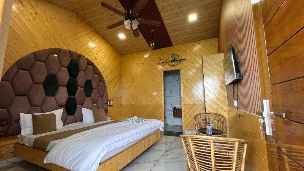a bedroom with a large bed and a ceiling fan at Msk Hotel & Restaurant in Jāmb