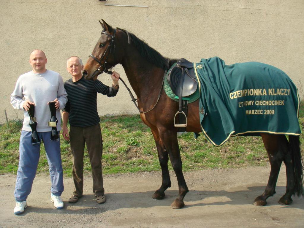 two men are standing next to a horse at Farma Bartolini in Piaseczno