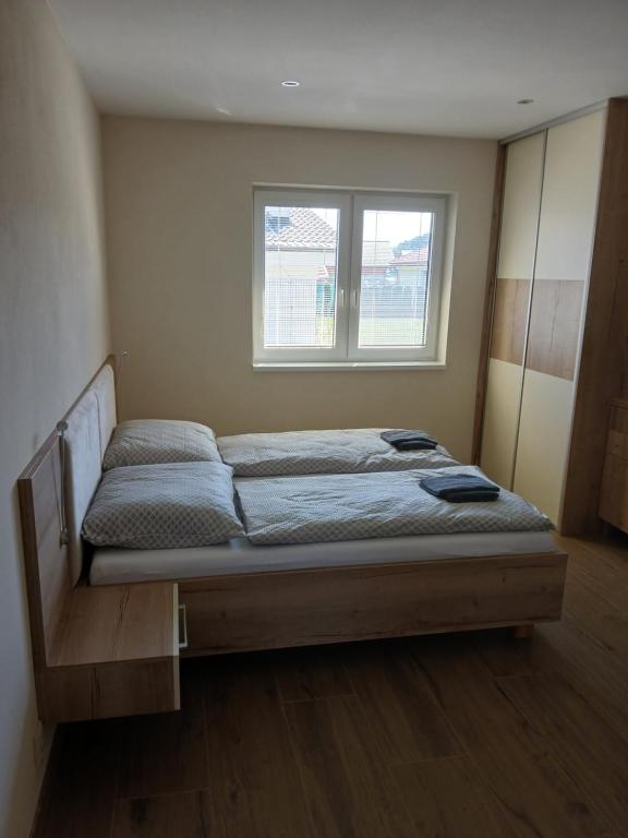 a bed in a room with a window at Apartmány ALTI in Prosiek