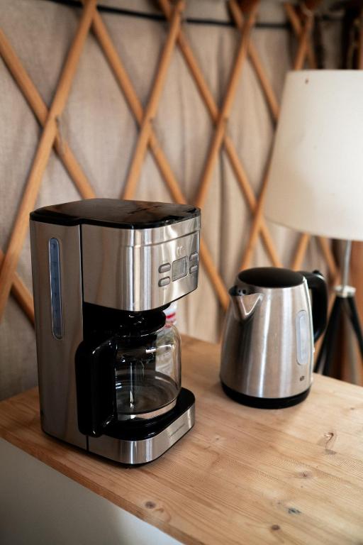 une cafetière posée sur une table en bois dans l'établissement Altitude Ecolodge Yourte, à Ilonse