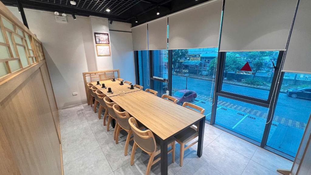 a conference room with a long wooden table and chairs at Uberzen Residence Hotel in An Dương