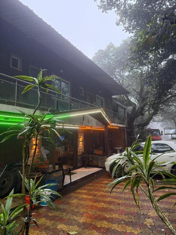 a house with a car parked in front of it at Hotel Green Forest Mahableshwar in Mahabaleshwar