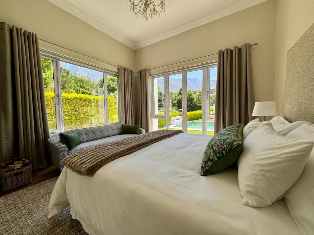 Un dormitorio con una cama grande con una ventana grande. en Bergzicht Villa, en Swellendam