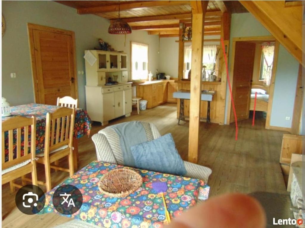 a living room with a couch and a kitchen at Dobra Chata in Cekcyn