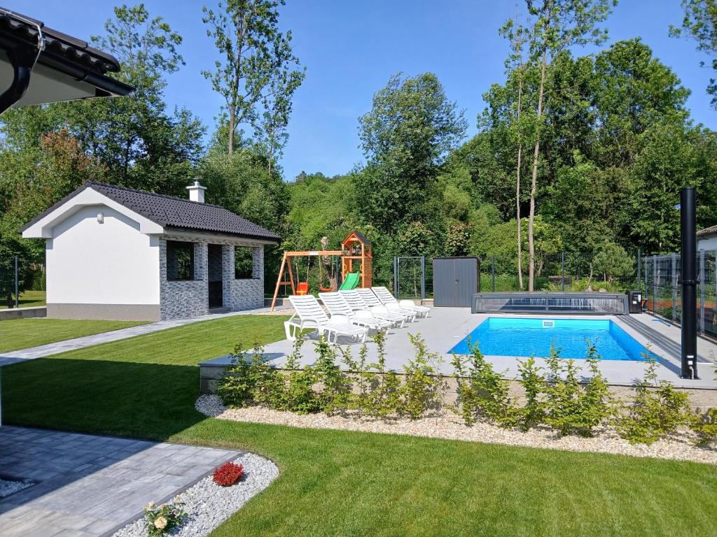 a backyard with a pool and a playground at Apartmány ALTI in Prosiek