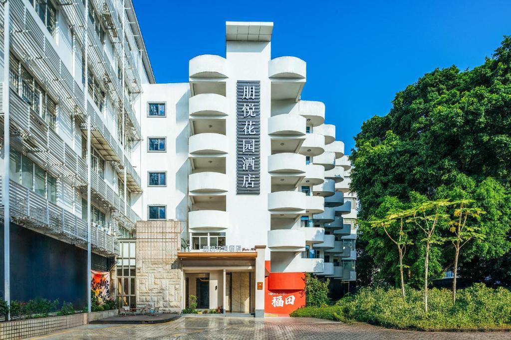 深圳Sentraland Pengyue Garden International Hotel Shenzhen Futian Shangmeilin Metro Station Branch的侧面有阳台的建筑