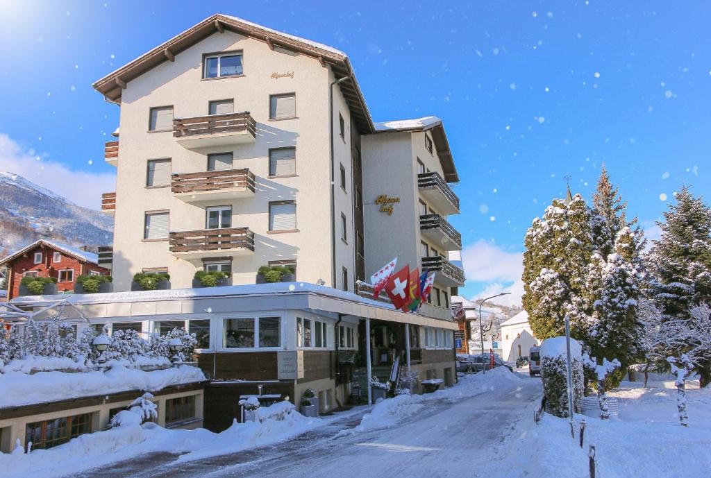 a hotel in the snow on a street at Hotel Alpenhof in Unterbäch