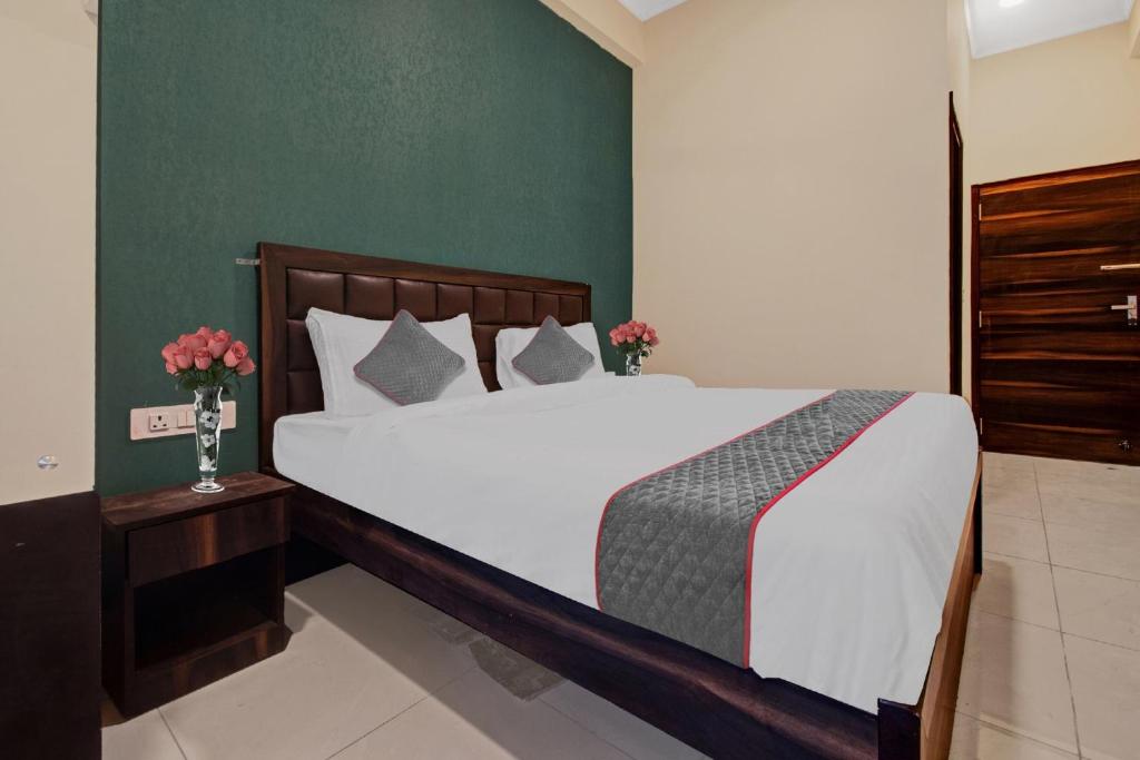 a bedroom with a large white bed with green walls at Collection O Aloft in Jaipur