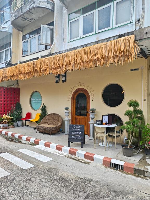 a building with a table and chairs in front of it at Bangkhunnon Station Hostel in Sathani Thon Buri