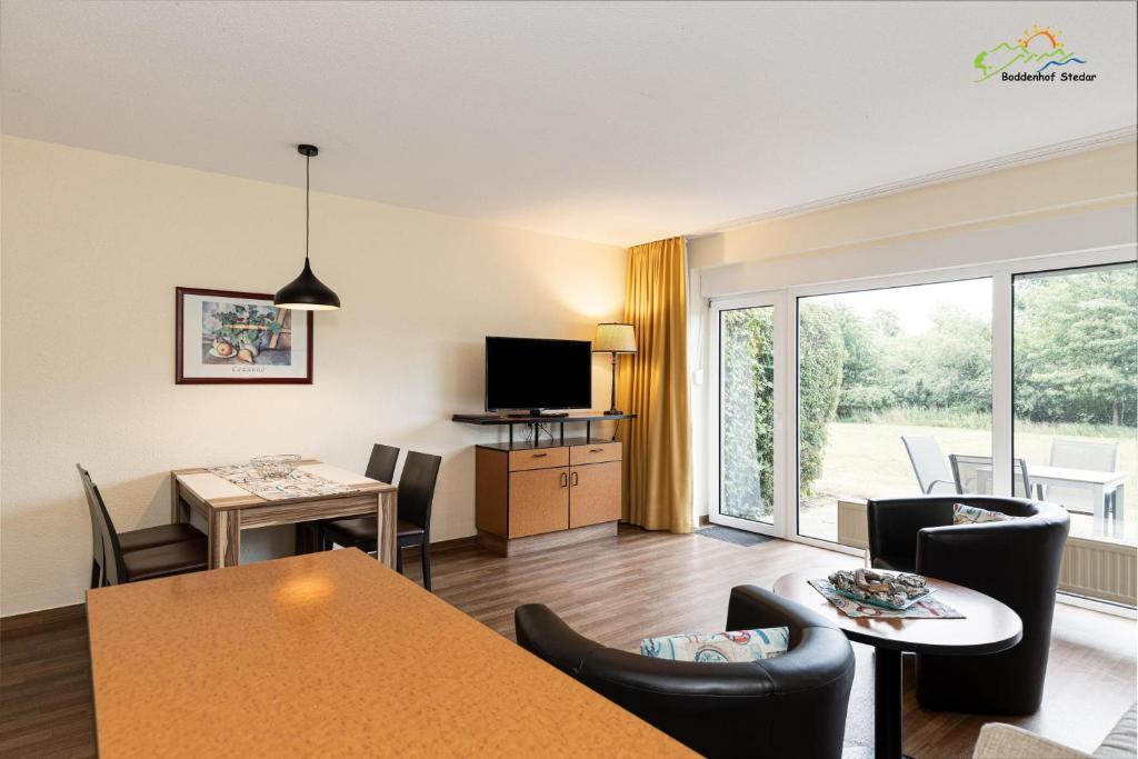 ein Wohnzimmer mit Tisch und Stühlen und einem Fernseher in der Unterkunft Apartment für Drei 44 in Stedar