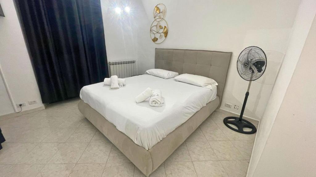 トリノにあるBnB Vercelli - Homezonのベッドルーム1室(白いシーツとファン付きのベッド1台付)