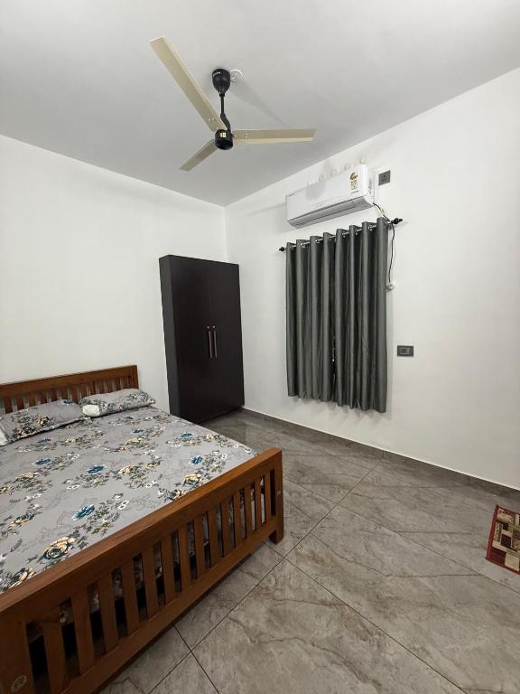 Un dormitorio con una cama y un ventilador de techo. en Varghese staycation, en Ernakulam